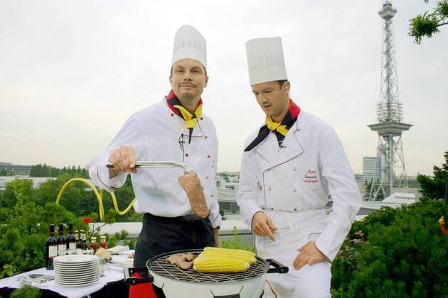 DSF Reporter Thomas Helmer (li.) und Fredi Bobic (beide Deutschland) rösten und grillen im Schatten des Berliner Funkturms Maiskolben und saftige Steaks auf einem Fußballgrill Fußball Herren WM 2006 Gruppe Kochsendung Berlin Fußball Herren WM 2006 Gruppe Kochsendung Berlin