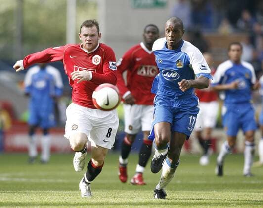 Wayne Rooney (Manchester United, li.) gegen Emmerson Boyce (Wigan) - EDITORIAL USE ONLY. No use with unauthorised audio, video, data, fixture lists, club league logos or live services. Online in-match use limited to 120 images, no video emulation. No use in betting, games or single club league player publications. Fußball Herren English Premier League 2006 2007, 1. Englische Liga, Wigan Athletic - Manchester United 1:3, ManU Gruppe Wigan Dynamik, Fußball Herren English Premier League 2006 2007, 1. Englische Liga, Wigan Athletic - Manchester United 1:3, ManU Gruppe Wigan Dynamik,