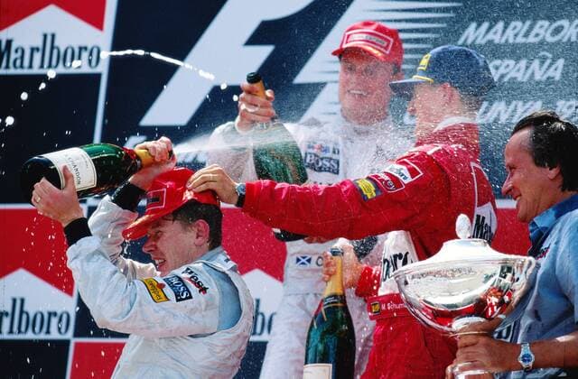 Siegerehrung beim GP von Spanien 1998: Sieger Mika Häkkinen (Finnland, li.) verpasst seinem Teamkollegen David Coulthard (2.v.li.), Schottland beide McLaren Mercedes) und Michael Schumacher (Deutschland Ferrari) eine Champagnerdusche; daneben... Motorsport Grand Prix Herren Großer Preis von Spanien 1998, Formel 1 Weltmeisterschaft, F1, F, GP, WM, Miteigentümer Teambesitzer Gruppe Circuit de Catalunya, Aufmacher Hakkinen Barcelona Freude, Begeisterung, Motorsport Grand Prix Herren Großer Preis von Spanien 1998, Formel 1 Weltmeisterschaft, F1, F, GP, WM, Miteigentümer Teambesitzer Gruppe Circuit de Catalunya, Aufmacher Hakkinen Barcelona Freude, Begeisterung,