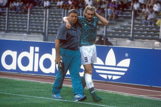 Mannschaftsarzt Prof. Dr. Heinrich Heß geleitet den verletzten Rudi Völler (beide BR Deutschland) vom Feld Fußball Länderspiel Herren WM 1990, Nationalmannschaft, Nationaltrikot, Halbfinale, BRD Gruppe Turin Enttäuschung, Nachdenklichkeit, Fußball Länderspiel Herren WM 1990, Nationalmannschaft, Nationaltrikot, Halbfinale, BRD Gruppe Turin Enttäuschung, Nachdenklichkeit,