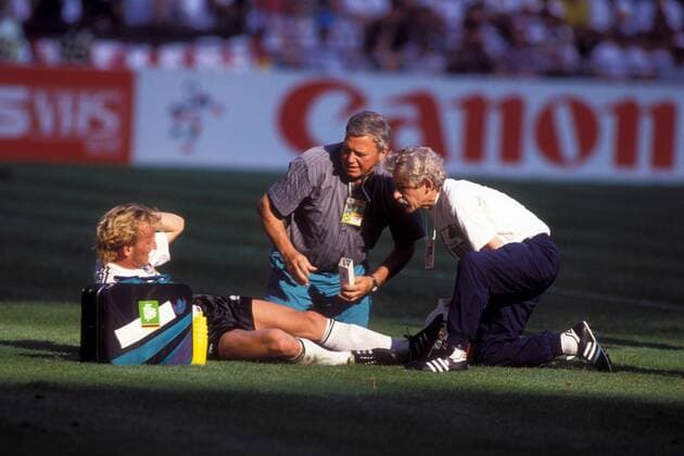 Andreas Brehme (li.) liegt verletzt am Boden und wird von Mannschaftsarzt Prof. Dr. Heinrich Heß (Mitte) und Masseur Adolf Katzenmaier (alle BR Deutschland) behandelt Fußball Länderspiel Herren WM 1990, Nationalmannschaft, Nationaltrikot, Viertelfinale, BRD Gruppe Mailand Fußball Länderspiel Herren WM 1990, Nationalmannschaft, Nationaltrikot, Viertelfinale, BRD Gruppe Mailand