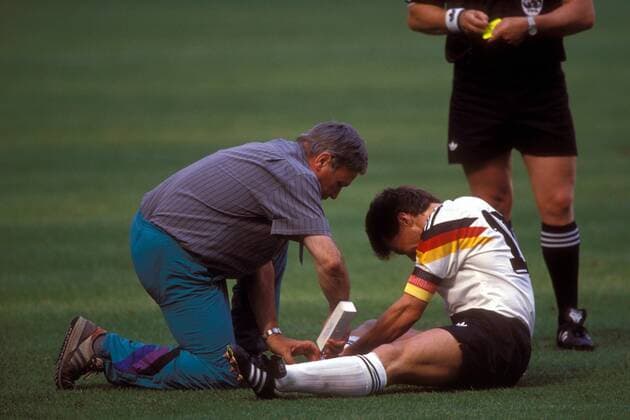 Lothar Matthäus (re.) sitzt verletzt am Boden und wird von Mannschaftsarzt Prof. Dr. Heinrich Heß (beide BR Deutschland) behandelt Fußball Länderspiel Herren WM 1990, Nationalmannschaft, Nationaltrikot, Viertelfinale, BRD Gruppe Mailand Fußball Länderspiel Herren WM 1990, Nationalmannschaft, Nationaltrikot, Viertelfinale, BRD Gruppe Mailand