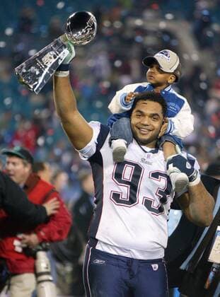 Richard Seymour (New England Patriots) feiert den Gewinn des Super Bowls 2005 gemeinsam mit seinem Sohn -  (sbp2005020692) American Football Herren NFL Super Bowl XXXIX 2004 2005, 39. Superbowl, Finale, Endspiel Gruppe Vince Lombardi Trophy Jacksonville Glück, Freude, American Football Herren NFL Super Bowl XXXIX 2004 2005, 39. Superbowl, Finale, Endspiel Gruppe Vince Lombardi Trophy Jacksonville Glück, Freude,