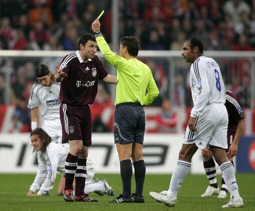 Schiedsrichter Lubos Michel (Slowakei) zeigt Mark van Bommel (Bayern, li.) die gelbe Karte Fußball EC 1 Herren Champions League 2006 2007, FC Bayern München - Real Madrid CF 2:1 Gruppe Achtelfinale München Fußball EC 1 Herren Champions League 2006 2007, FC Bayern München - Real Madrid CF 2:1 Gruppe Achtelfinale München