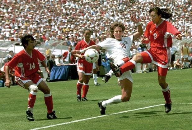 IMAGO Iconic Moments, Fußball - Frauen Michelle Akers (Mitte, USA) gegen Jin Yan (re.) und Bai Jie (beide China) -  (LAP99071124) Fußball Länderspiel Damen WM 1999, Finale, Endspiel, Nationalmannschaft, Nationaltrikot, USA - China 5:4 n.E., Vdig Gruppe Frauen, Frauenfußball Los Angeles Dynamik, Kampf, Fußball Länderspiel Damen WM 1999, Finale, Endspiel, Nationalmannschaft, Nationaltrikot, USA - China 5:4 n.E., Vdig Gruppe Frauen, Frauenfußball Los Angeles Dynamik, Kampf,