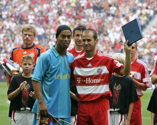 Ronaldinho (FC Barcelona, li.) überreicht Mehmet Scholl (re.) zu dessen Abschiedsspiel ein Präsent, verfolgt mit skeptischen Blicken von Torwart Oliver Kahn (hi.li., beide Bayern) Fußball Herren Mehmet Scholls Abschiedsspiel 2007, FC Bayern München, Barca, Gruppe München Fußball Herren Mehmet Scholls Abschiedsspiel 2007, FC Bayern München, Barca, Gruppe München