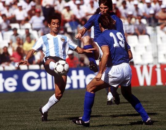 Osvaldo Ardiles (Argentinien, li.) gegen Francesco Graziani (re.) und Gabriele Oriali (beide Italien) -  Fußball Länderspiel Herren WM 1982, Nationalmannschaft, Nationaltrikot, Zwischenrunde, Gruppe C Gruppe Barcelona Dynamik Fußball Länderspiel Herren WM 1982, Nationalmannschaft, Nationaltrikot, Zwischenrunde, Gruppe C Gruppe Barcelona Dynamik