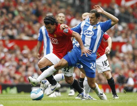 Carlos Tevez (Manchester United, li.) gegen Josip Skoko (Wigan) - EDITORIAL USE ONLY. No use with unauthorised audio, video, data, fixture lists, club league logos or live services. Online in-match use limited to 120 images, no video emulation. No use in betting, games or single club league player publications. Fußball Herren English Premier League 2007 2008, 1. Englische Liga, Manchester United - Wigan Athletic 4:0, ManU Gruppe Manchester Dynamik, Fußball Herren English Premier League 2007 2008, 1. Englische Liga, Manchester United - Wigan Athletic 4:0, ManU Gruppe Manchester Dynamik,