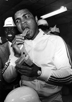 Muhammad Ali (USA) beißt herzhaft in seinen neuen Crisp Crunch Riegel -  (ARK1978082164) Boxen Herren Boxsport 1978, Profiboxen, Schwergewicht, Aufmacher Einzelbild Lititz Boxen Herren Boxsport 1978, Profiboxen, Schwergewicht, Aufmacher Einzelbild Lititz