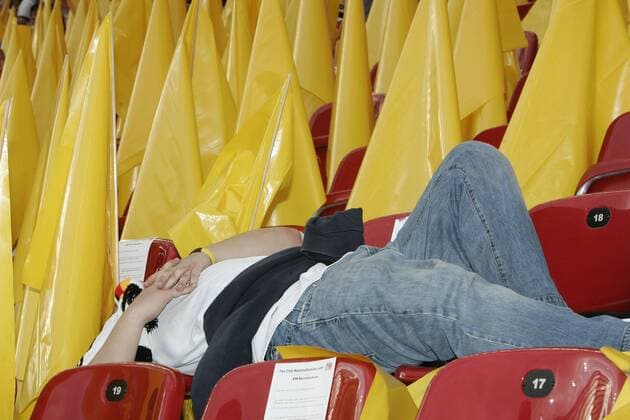 Ein deutscher Fan wird auf der Tribüne zwischen gelben Fahnen von seiner Müdigkeit überwältigt Fußball Länderspiel Herren EURO 2008, EM, Nationalteam, Deutschland Einzelbild Klagenfurt
