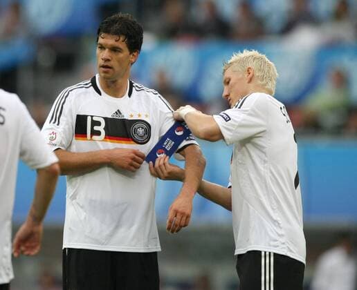 Michael Ballack (li.) läßt sich von Bastian Schweinsteiger (beide Deutschland) die Kapitänsbinde anlegen Fußball EM Herren Euro 2008, Länderspiel, Nationalmannschaft, Nationaltrikot, Gruppe Klagenfurt