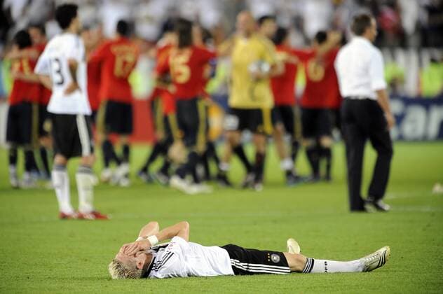 Bastian Schweinsteiger (Deutschland) verzweifelt am Boden, dahinter jubeln die spanischen Spieler über den Gewinn der EM 2008 Fußball EM Herren Euro 2008, Länderspiel, Finale, Nationalmannschaft, Nationaltrikot, Deutschland - Spanien 0:1 Totale Wien Freude, Enttäuschung, Verzweiflung,