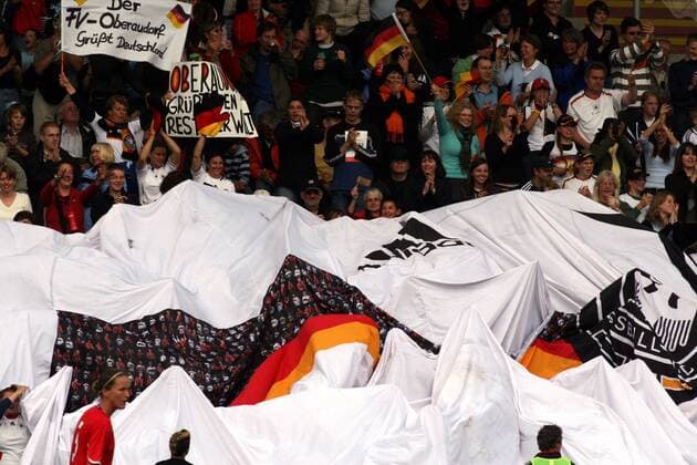 Deutsche Fans breiten ein Riesentrikot der EM Kampagne - Fans2008 - auf der Tribüne aus Fußball Länderspiel Damen Test 2008, Testspiel, Freundschaftsspiel, Nationalmannschaft, Nationaltrikot Totale Unterhaching Freude, Begeisterung,