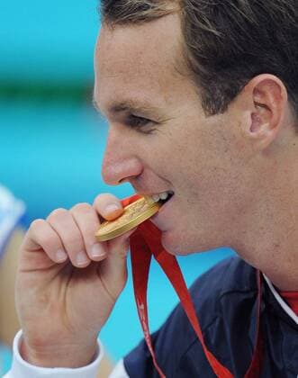 Aaron Peirsol (USA), Olympiasieger über 100m Rücken, prüft seine Goldmedaille -  Schwimmen OS Sommer Herren Olympische Spiele 2008, Sommerspiele, 100m Rücken Einzelbild Peking Freude,