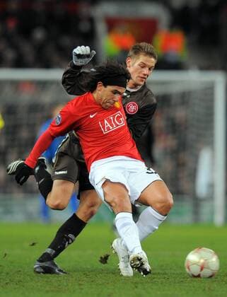 Carlos Tevez (Manchester United, vorn) gegen Kasper Risgard (Aalborg) - EDITORIAL USE ONLY. No use with unauthorised audio, video, data, fixture lists, club league logos or live services. Online in-match use limited to 120 images, no video emulation. No use in betting, games or single club league player publications. Fußball EC 1 Herren Champions League 2008 2009, Manchester United - Aalborg BK, ManU Gruppe Manchester Dynamik,
