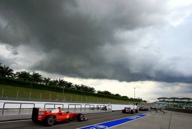 Boliden u.a. Felipe Massa (Brasilien Ferrari, li.) verlassen die Boxengassenausfahrt unter düsteren Wolken über dem Sepang International Circuit Motorsport Grand Prix Herren Großer Preis von Malaysia 2009, Formel 1 Weltmeisterschaft, F1, F, GP, WM, Qualifying Totale Kuala Lumpur Sepang