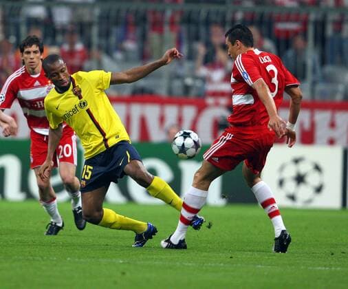 Seydou Keita (FC Barcelona, Mitte) gegen Lucio (Bayern, re.) -  Fußball EC 1 Herren Champions League 2008 2009, FC Bayern München - FC Barcelona, Barca Gruppe München Dynamik,