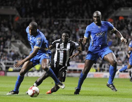 Obafemi Martins (Newcastle, Mitte) gegen Sylvain Distin (li.) und Sol Campbell (beide Portsmouth) - EDITORIAL USE ONLY. No use with unauthorised audio, video, data, fixture lists, club league logos or live services. Online in-match use limited to 120 images, no video emulation. No use in betting, games or single club league player publications. Fußball Herren English Premier League 2008 2009, 1. Englische Liga, Newcastle United - Portsmouth FC 0:0 Gruppe Newcastle Dynamik,
