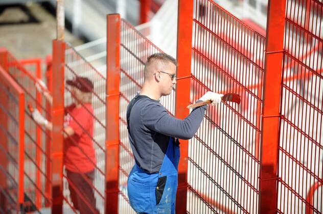 Maler streicht den Zaun im Stadion An der Alten Försterei rot an - Modernisierung der Heimspielstätte von Union Berlin Fußball Herren 3. Liga 2008 2009, 1. FC Union Berlin Einzelbild Alte Försterei Berlin