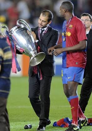 Trainer Josep Guardiola schaut sich die Trophäe genau an, re. Yaya Toure - FC Barcelona ist Champions League Sieger 2009 Fußball EC 1 Herren Champions League Finale 2008 2009, FC Barcelona, Barca Gruppe Rom Freude,