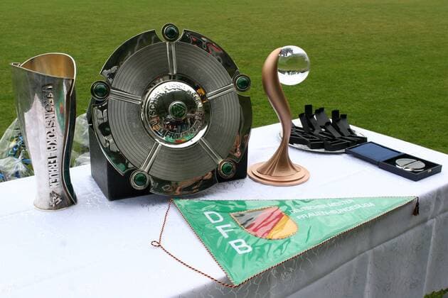 3 Trophäen vor einem DFB Wimpel symbolisieren das Triple im Frauenfußball - V.li. DFB Pokal, Meisterschale, UEFA Pokal Fußball 1. BL Damen Saison 2008 2009, Frauen, Frauenfußball Gruppe Duisburg
