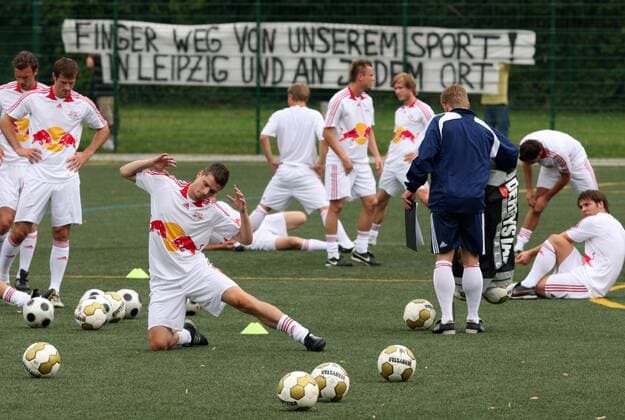 Training RB Leipzig in Trikots von Red Bull Salzburg während am Zaun ein Protestbanner hängt: Finger weg von unserem Sport in Leipzig und an jedem Ort Fußball Herren NOFV Oberliga Süd Nordost 2009 2010, RasenBallsport Leipzig, Rasenball, RB, Training Totale Markranstädt