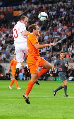 Wayne Rooney (L) of England rises above Joris Mathijsen of Holland EDITORIAL USE ONLY. No use with unauthorised audio, video, data, fixture lists, club league logos or live services. Online in-match use limited to 120 images, no video emulation. No use in betting, games or single club league player publications.