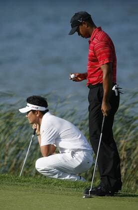 Tiger Woods (USA, R) looks at his ball as Y. E. Yang of South Korea lines up his putt  BKX2009081630 o0 Eldrick