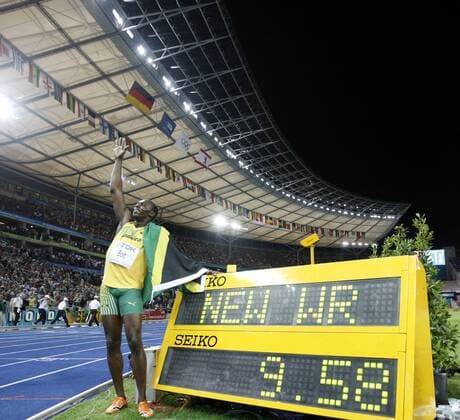Jamaica s Usain Bolt celebrates beside the result board after winning the men s 100m final. Bolt set a new world record with a time of 9.58 seconds and claimed the title of the event. 