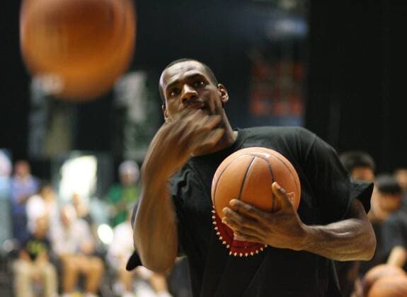 BEIJING, NBA, Aug. 24, 2009 LeBron James of the Cleveland Cavaliers tosses basketballs to the audience at the end of a promotional event in Beijing August 24, 2009. James is in China on a worldwide tour to promote a product and to offer grass-roots basketball activities. (Xinhua Meng Yongmin) 