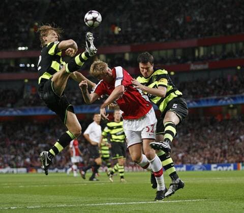 Arsenal FC London s Nicklas Bendtner (C) tussles with Celtic Glasgow s Glenn Loovens (L) and Gary Caldwell EDITORIAL USE ONLY. No use with unauthorised audio, video, data, fixture lists, club league logos or live services. Online in-match use limited to 120 images, no video emulation. No use in betting, games or single club league player publications.