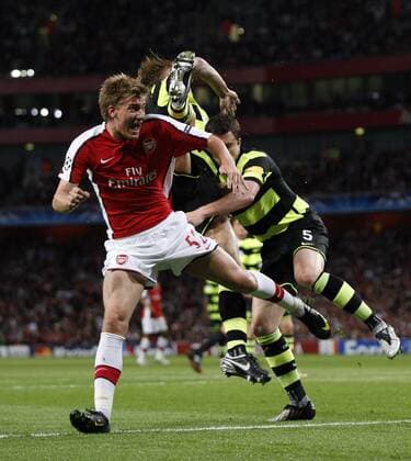 Arsenal FC London s Nicklas Bendtner tussles with Celtic Glasgow s Gary Caldwell (R) EDITORIAL USE ONLY. No use with unauthorised audio, video, data, fixture lists, club league logos or live services. Online in-match use limited to 120 images, no video emulation. No use in betting, games or single club league player publications.