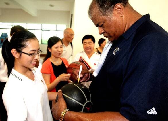 Wes Unseld of Washington Wizards signs a signature for a girl at Shanghai Nanyang Model High School in Shanghai 