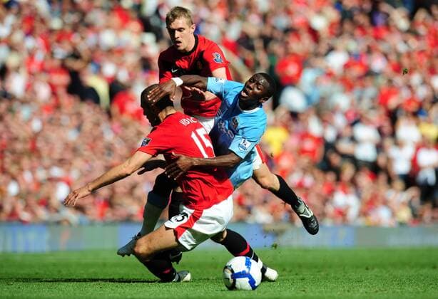 Shaun Wright-Phillips (R) of Manchester City brought down by Nemanja Vidic (L) of Manchester United and Darren Fletcher of Manchester United - EDITORIAL USE ONLY. No use with unauthorised audio, video, data, fixture lists, club league logos or live services. Online in-match use limited to 120 images, no video emulation. No use in betting, games or single club league player publications. o0 ManU