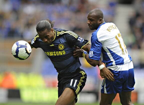 Chelsea s Didier Drogba (L) keeps Wigan s Emmerson Boyce away from the ball. Barclays Premier League Wigan Athletic v Chelsea 26th September, 2009 EDITORIAL USE ONLY. No use with unauthorised audio, video, data, fixture lists, club league logos or live services. Online in-match use limited to 120 images, no video emulation. No use in betting, games or single club league player publications. o0 FC