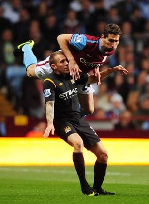 Carlos Cuellar of Aston Villa (R) goes over Craig Bellamy of Manchester City - EDITORIAL USE ONLY. No use with unauthorised audio, video, data, fixture lists, club league logos or live services. Online in-match use limited to 120 images, no video emulation. No use in betting, games or single club league player publications. o0 Birmingham
