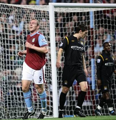 Richard Dunne of Aston Villa celebrates whilst Gareth Barry of Manchester City looks dejected. - EDITORIAL USE ONLY. No use with unauthorised audio, video, data, fixture lists, club league logos or live services. Online in-match use limited to 120 images, no video emulation. No use in betting, games or single club league player publications. o0 Birmingham
