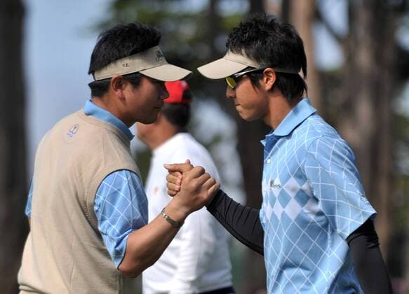 International team member Ryo Ishikawa (R) is congratulated by teammate Y.E. Yang after making a putt for birdie on the 2nd green during the second round of The Presidents Cup at Harding Park Golf Course in San Francisco, California on October 9, 2009.  SFP20091009311 o00 The President s