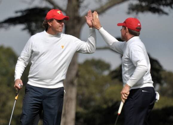 United States team member Phil Mickelson (L) celebrates with teammate Justin Leonard after Leonard made a putt for birdie on the 1st green during the second round of The Presidents Cup at Harding Park Golf Course in San Francisco, California on October 9, 2009.  SFP20091009314 o0 USA, o00 The President s