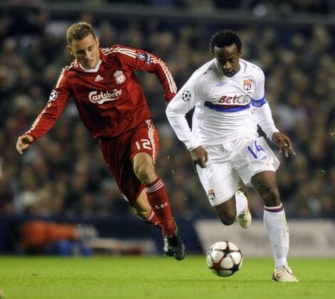 Lyon s Sidney Govou (R) takes on FC Liverpool s Fabio Aurelio. - EDITORIAL USE ONLY. No use with unauthorised audio, video, data, fixture lists, club league logos or live services. Online in-match use limited to 120 images, no video emulation. No use in betting, games or single club league player publications. o0 OL, Olympique Lyonnais