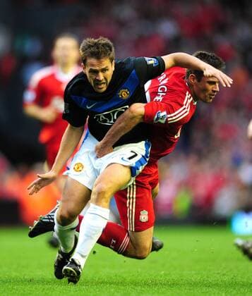 Michael Owen of Manchester United (L) is brought down by Jamie Carragher of FC Liverpool EDITORIAL USE ONLY. No use with unauthorised audio, video, data, fixture lists, club league logos or live services. Online in-match use limited to 120 images, no video emulation. No use in betting, games or single club league player publications.