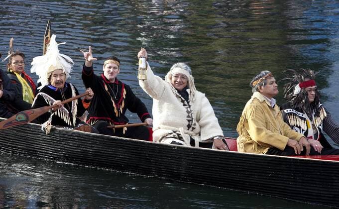 Chief Gibby Jacob (3.R.) of the Squamish First Nation holds the Olympic Flame as he and other First Nation Chiefs transport the Flame in a miners lantern across Victoria harbour to the British Columbia (BC) Legislature where it will light a 1.2-meter community celebration cauldron before the start of the 2010 Winter Olympic Torch Relay in Victoria -  VIC2009103034 o0 Häuptling, Indianer, Kanu, Boot