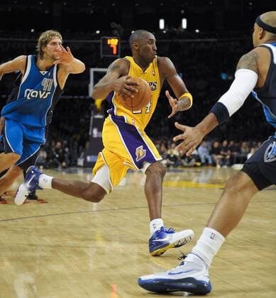Kobe Bryant(C) of Lakers breaks through during the match between Los Angeles Lakers and Dallas Mavericks, left: Dirk Nowitzki 