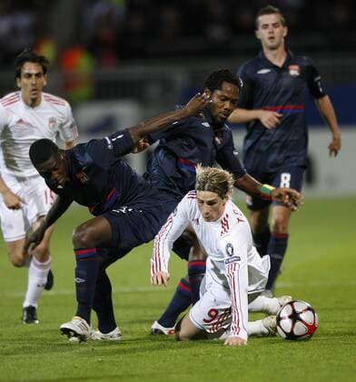 Lyon s Jean II Makoun (C) and Lamine Gassama (l.) tussle with Liverpool s Fernando Torres - UEFA Champions League Group E Olympique Lyonnais v FC Liverpool 4th November, 2009 EDITORIAL USE ONLY. No use with unauthorised audio, video, data, fixture lists, club league logos or live services. Online in-match use limited to 120 images, no video emulation. No use in betting, games or single club league player publications.
