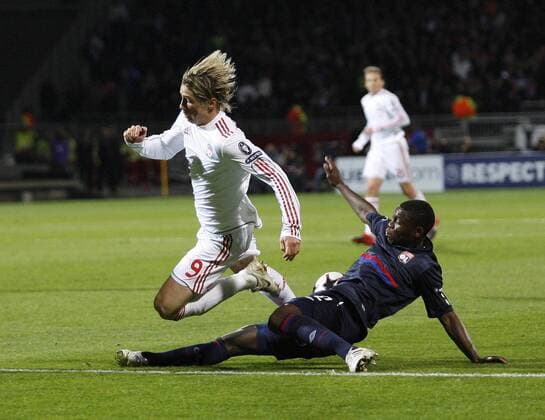 Lyon s Lamine Gassama (R) tussles with Liverpool s Fernando Torres, Olympique Lyon - Liverpool FC - EDITORIAL USE ONLY. No use with unauthorised audio, video, data, fixture lists, club league logos or live services. Online in-match use limited to 120 images, no video emulation. No use in betting, games or single club league player publications.