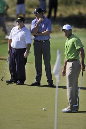 IAN BAKER FINCH (Australia, center) and CRAIG PARRY (Australia) share information as TIGER WOODS (USA) puts during practice. - ZUMAmm5