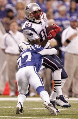 New England Patriots wide receiver Randy Moss (81) is hit by Indianapolis Colts defensive back Jacob Lacey (27) during the fourth quarter at Lucas Oil Field in Indianapolis on November 15, 2009. The Colts defeated the Patriots 35-34  IND2009111522