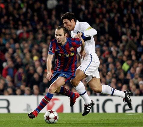 FC Barcelona s Andres Iniesta (L) fight for the ball with Inter Milan s Javier Zanetti during their Champions League football match at Camp Nou stadium in Barcelona, 24 November 2009. - PacoxSerinelli