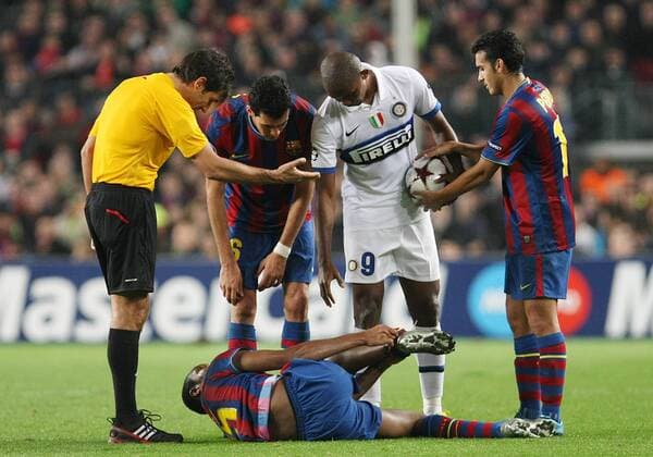 FC Barcelona s Sergio Busquets (l) and Pedro Rodriguez (r) and Seydou Keita injured (d), Inter Milan s Samuel Eto o (c) and the referee Massimo Busacca during the Champions League match.November 24 2009.  (20115353)