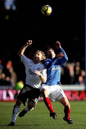 Dirk Kuyt of Liverpool FC (L) and Hermann Hreidarsson of Portsmouth fight for the ball Barclays Premier League Portsmouth v Liverpool 19th December, 2009 EDITORIAL USE ONLY. No use with unauthorised audio, video, data, fixture lists, club league logos or live services. Online in-match use limited to 120 images, no video emulation. No use in betting, games or single club league player publications.